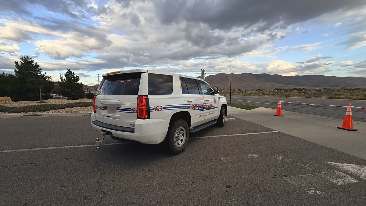 EMVIPS volunteer Tahoe marked Utah County Sheriff Volunteer, rear view under a cloudy sky.